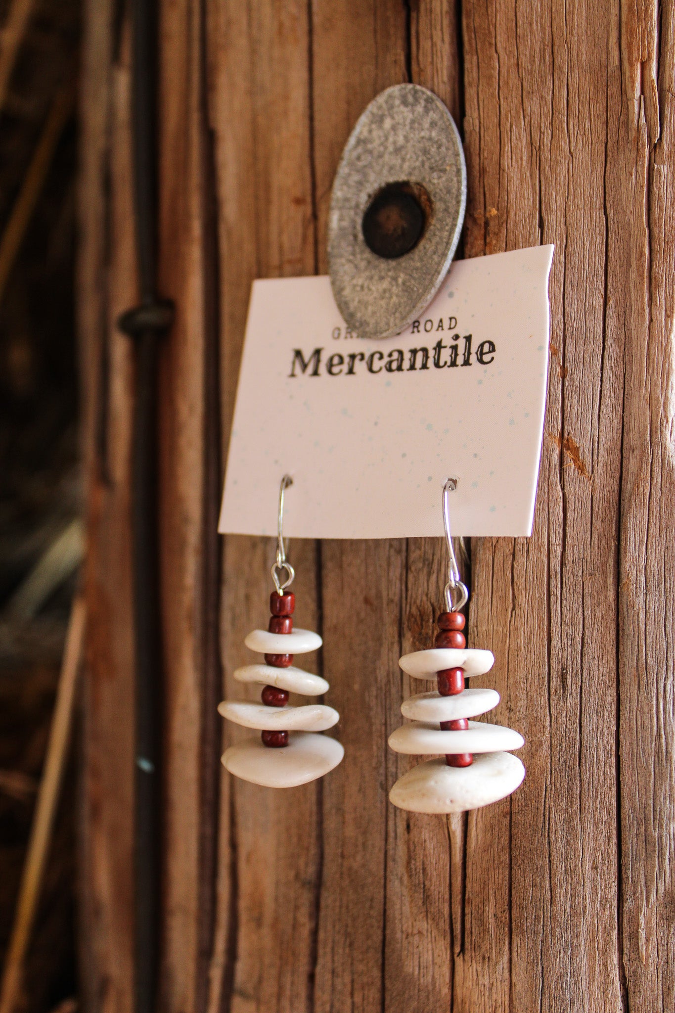 white layered earrings with rust beads between